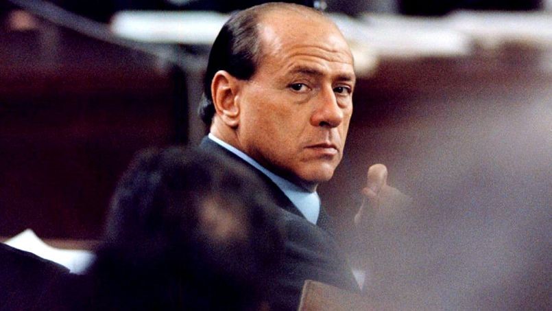 Italy's former Prime Minister Silvio Berlusconi looks back as he faces his accusers in public for th..