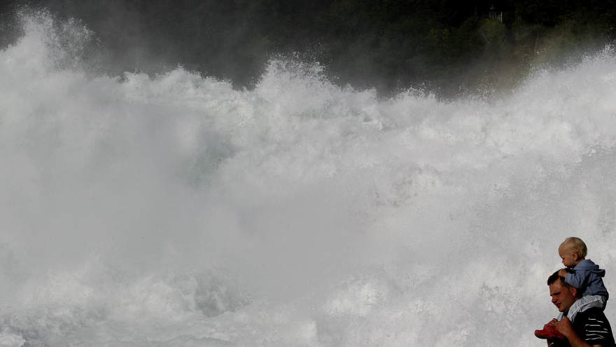 Tourists look at the Rhine Falls in the town of Neuhausen