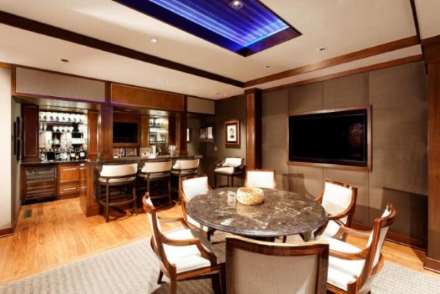 the-basement-has-a-purple-ceiling-light-and-bar