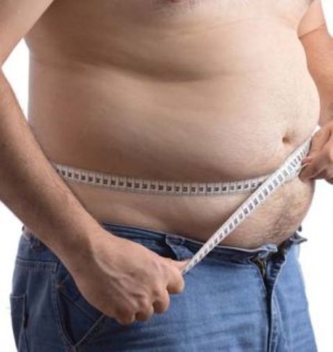 Fat man holding a measurement tape against white background