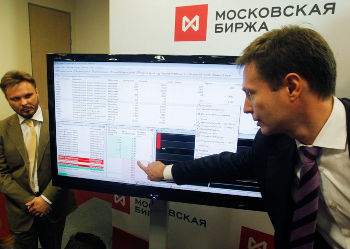 Employees of the Moscow Exchange demonstrate a point on a screen after the start of trading in Moscow