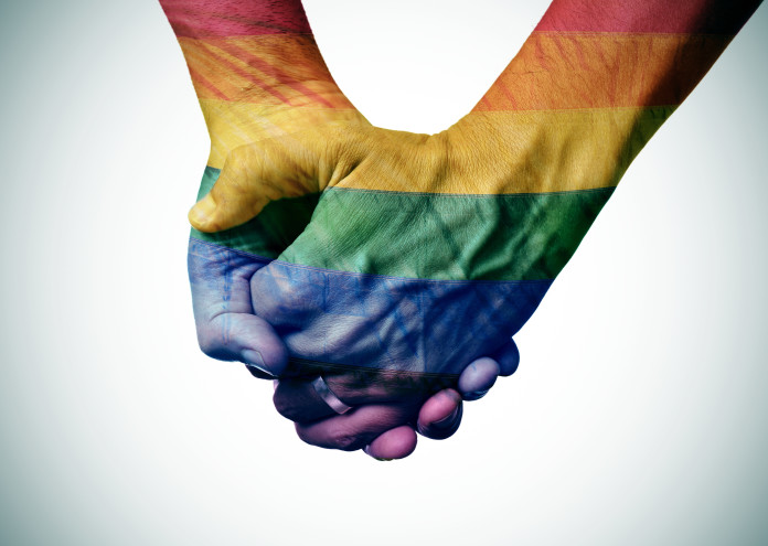 gay couple holding hands, patterned as the rainbow flag
