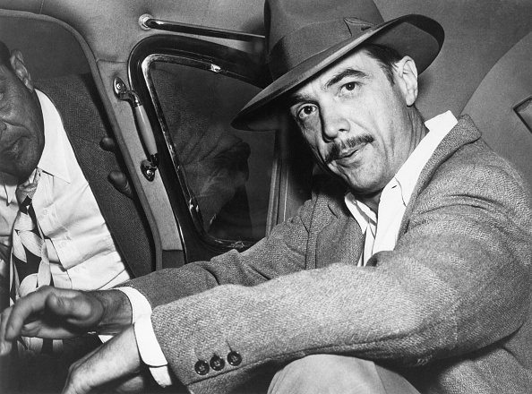  Howard Hughes seated in an automobile. 