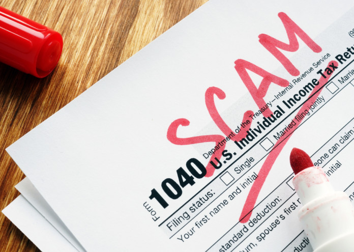  Tax scam. Form with sign on a desk. 