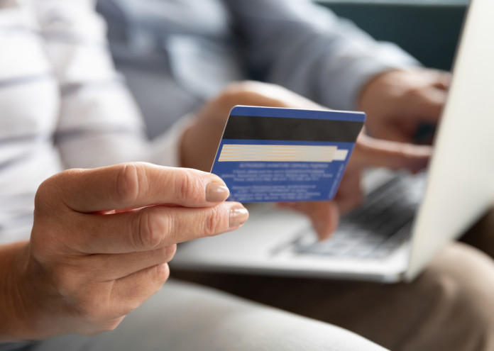  Female holding credit card making online payment, closeup view 
