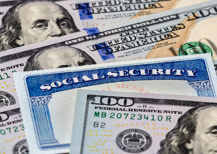 Social Security benefits identification card with 100 dollar bills