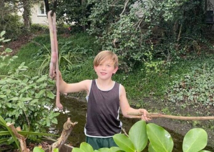 Деветгодишният Барнаби Домиган копае около речно корито на ръба на